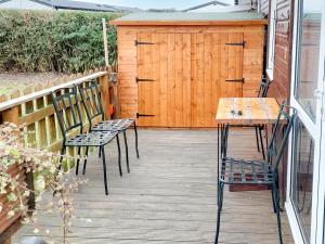 two chairs and a wooden table on a deck at The Revie in Bridlington +7 photos