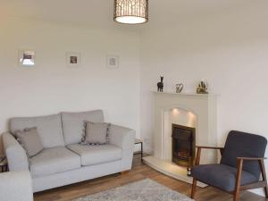 a living room with a couch and a fireplace at Bernicia House in Seahouses