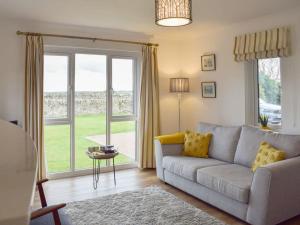 a living room with a couch and a large window at Bernicia House in Seahouses