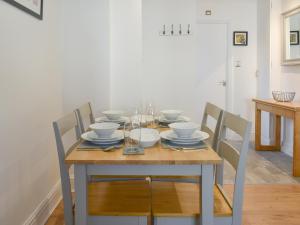 a dining room table with bowls and plates on it at The Snug in Bowness-on-Windermere