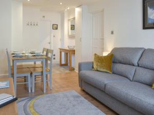 a living room with a couch and a dining room at The Snug in Bowness-on-Windermere