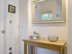 a bathroom with a wooden table with a mirror at The Snug in Bowness-on-Windermere