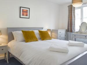 a white bed with two towels on top of it at The Snug in Bowness-on-Windermere +9 photos