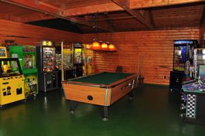 um quarto com uma mesa de bilhar e várias máquinas de jogos em Arrowhead Camping Resort Deluxe Cabin 14 em Douglas Center