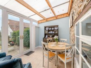 a conservatory with a table and chairs at Lillie's Cottage in Sewerby