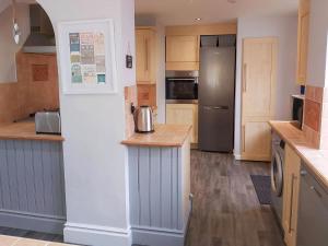 a kitchen with a refrigerator and a counter top at Croeso in Conwy