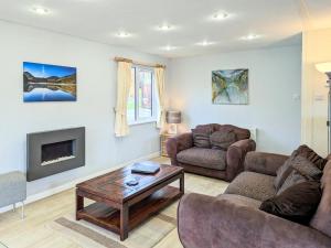 a living room with a couch and a table at Bowness Lodge 12 Fellside in Windermere