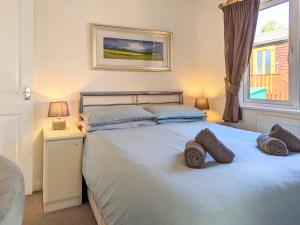 a bedroom with a large bed with towels on it at Bowness Lodge 12 Fellside in Windermere