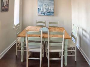 a dining room table with white chairs around it at India Lane Cottage in Montrose