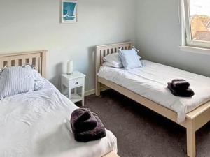 a bedroom with two beds with towels on them at India Lane Cottage in Montrose +4 photos