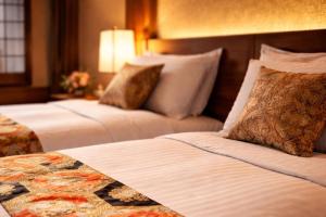 a hotel room with two beds and a lamp at AKARI Kyoto Gion in Kyoto