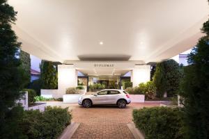 キャンベラにあるRamada Diplomat Canberraの建物前に駐車した白車