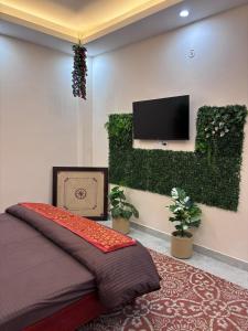 a bedroom with a bed and a tv on the wall at Whispering Vines by Blessings in Rishīkesh