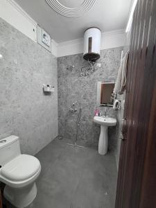 a bathroom with a toilet and a sink at Whispering Vines by Blessings in Rishīkesh +21 photos