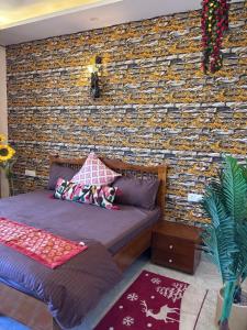 a bedroom with a brick wall and a bed at Whispering Vines by Blessings in Rishīkesh