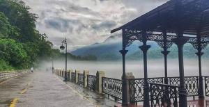 a gazebo next to a body of water with fog at Whispering Vines by Blessings in Rishīkesh