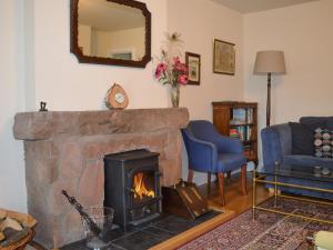 ein Wohnzimmer mit Kamin und Spiegel in der Unterkunft Old Steading in Brodick