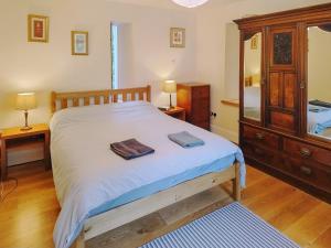 ein Schlafzimmer mit einem Bett, einer Kommode und einem Spiegel in der Unterkunft Old Steading in Brodick + 17 Fotos