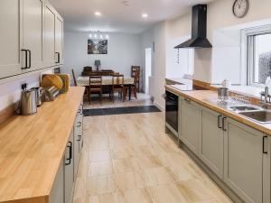 eine Küche mit Holzarbeitsplatten und ein Esszimmer in der Unterkunft Old Steading in Brodick