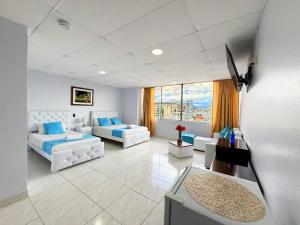 a living room with white furniture and a large window at Hotel Santamaria en quito in Quito