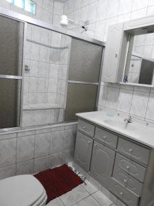 a bathroom with a toilet and a sink and a mirror at Pousada Ritmo Natureza in São Thomé das Letras