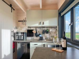 a kitchen with two wine glasses on a counter at Barn Owl Cabin - Uk45401 in Forfar
