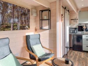 a living room with two chairs and a table at Barn Owl Cabin - Uk45401 in Forfar