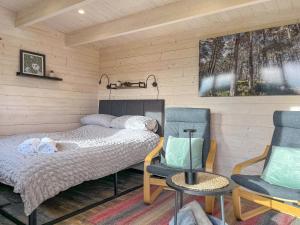 a bedroom with a bed and two chairs at Barn Owl Cabin - Uk45401 in Forfar