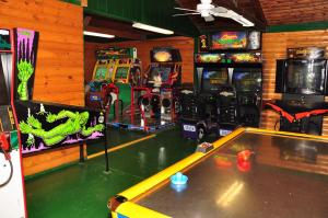uma sala de jogos com mesa e jogos de arcada em Arrowhead Camping Resort Park Model 10 em Douglas Center