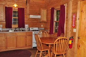 una cocina con mesa y sillas en una cabaña en Tranquil Timbers Deluxe Cabin 6, en Sturgeon Bay