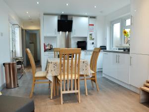 a kitchen and dining room with a table and chairs at Lle Clyd in Harlech
