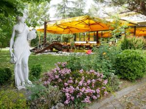 a statue of a woman in a garden with flowers at Hotel Il Maglio in Imola