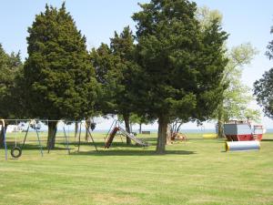 un parc avec des balançoires et des arbres dans l'herbe dans l'établissement Virginia Landing Camping Resort Cabin 2, à Quinby