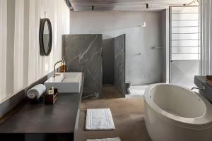 a bathroom with a tub and a sink and a toilet at Casa Pantuso - Vale do Sol in Nova Lima +27 photos