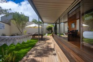 an external view of a house with a wooden deck at Casa Pantuso - Vale do Sol in Nova Lima