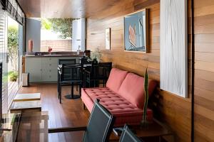 a living room with a red couch and a kitchen at Casa Pantuso - Vale do Sol in Nova Lima