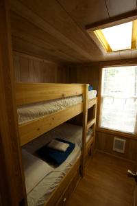 two bunk beds in a cabin with a window at Arrowhead Camping Resort Deluxe Cabin 4 in Douglas Center