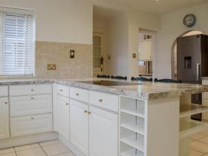 a kitchen with white cabinets and a marble counter top at New Inn House in Harvington