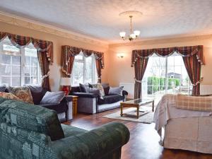 a living room with a couch and chairs and windows at New Inn House in Harvington