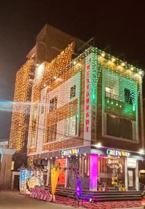 a building with christmas lights on the side of it at GREEN WAY HOTEL & RESTAURANt in Gangānagar