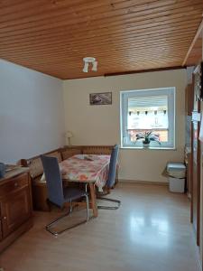 a dining room with a table and chairs and a window at Fewo Sabrina EG & OG in Raisting