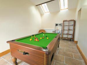 a pool table with balls on it in a room at Rievaulx Cottage in Filey