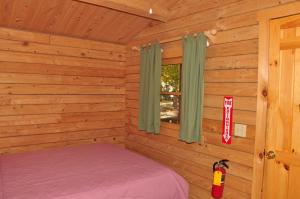 a log cabin with a bed and a window at Tranquil Timbers Cabin 11 in Sturgeon Bay