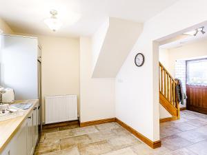 a kitchen with white walls and a stair case at Water's Edge - Uk32390 in Dunford Bridge