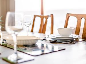 a table with glasses and plates and a bowl at Water's Edge - Uk32390 in Dunford Bridge