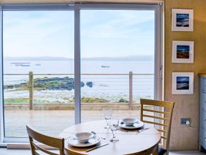 a dining room with a table with a view of the ocean at The Duckling in Port na Long