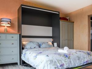 a bedroom with a large bed with a black headboard at The Duckling in Port na Long
