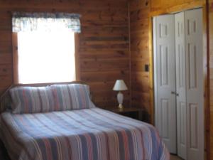 1 dormitorio con cama, ventana y ventana en Virginia Landing Camping Resort Cabin 19, en Quinby