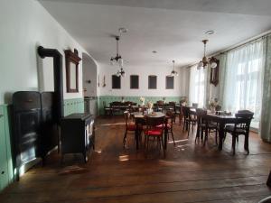 a dining room with tables and chairs and a fireplace at Penzion Nad Kašnou in Kašperské Hory