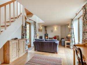 a living room with a couch and a staircase at Hopewell Barn in Hewelsfield